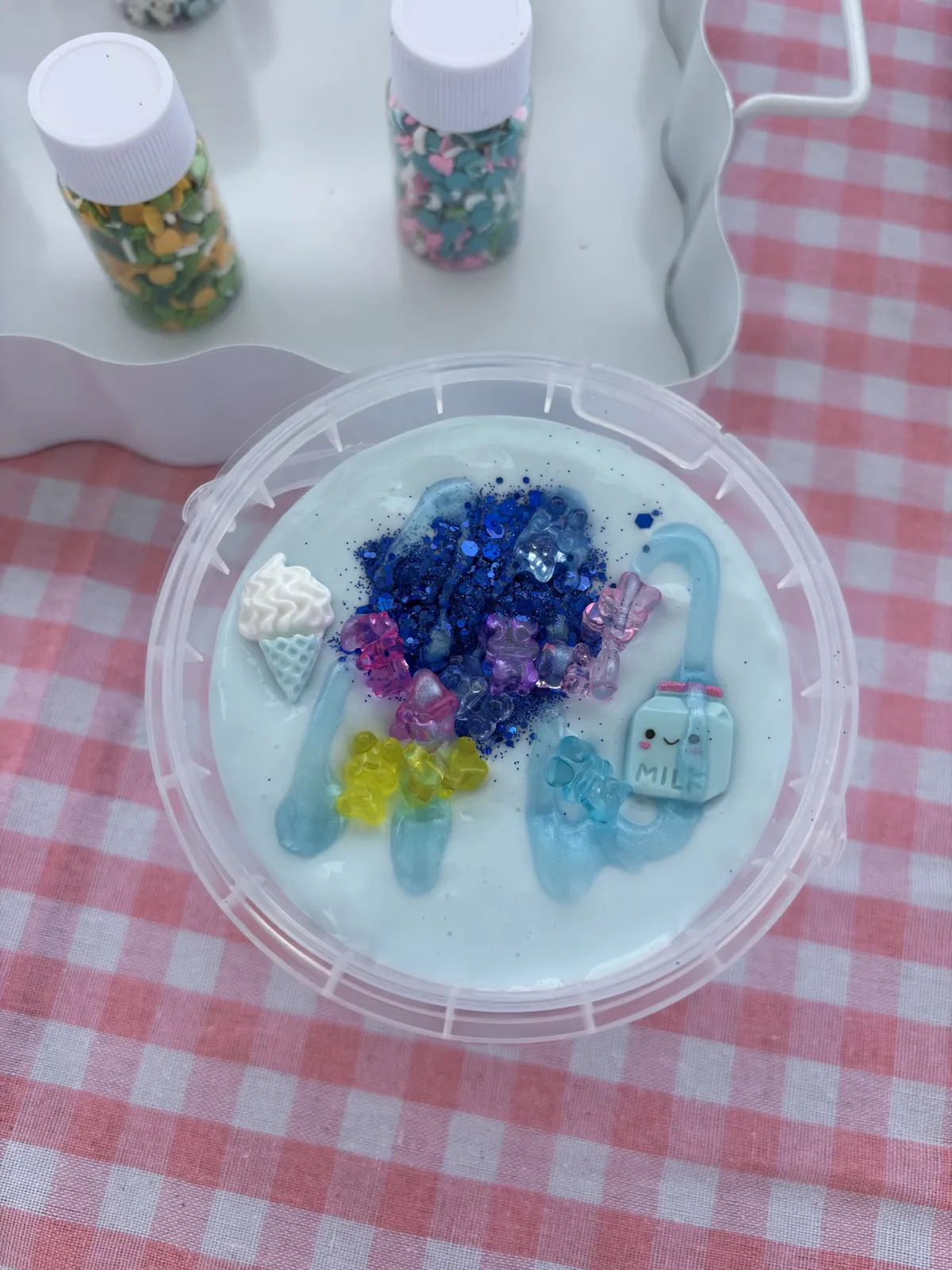Light blue slime with blue glitter, an ice cream cone charm, and a milk carton charm