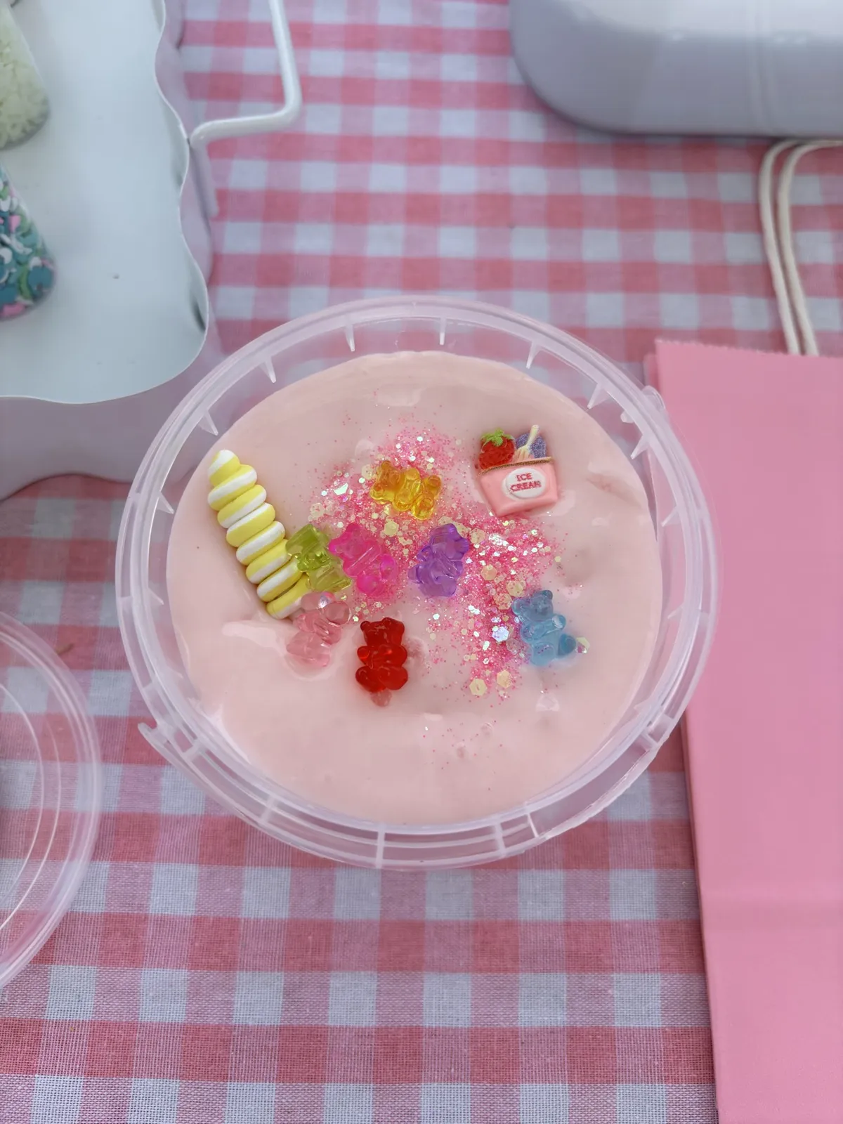 Pink strawberry slime topped with gummy bear charms and glitter