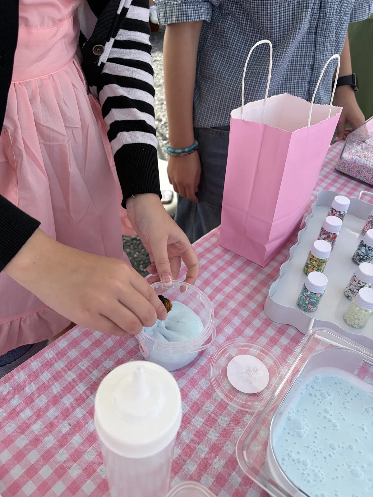 Adding scent drops to a cup of blue slime